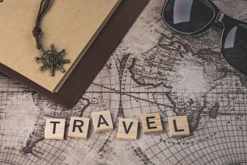 pexels photo 14131700 14131700 1 Close-up of travel items including map, helm pendant, notebook, and sunglasses.